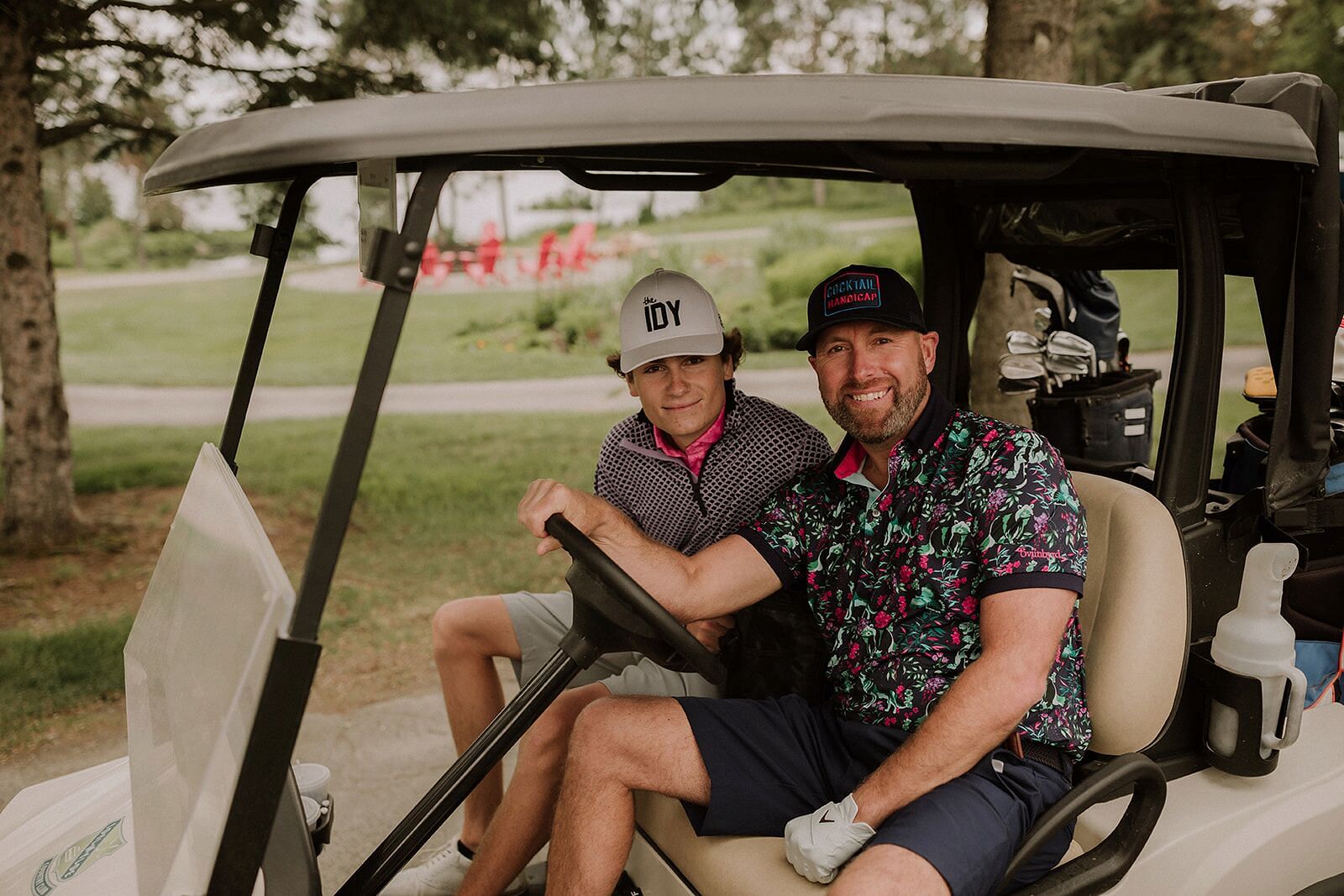 Two people in golf cart smiling