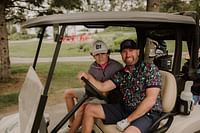 two people in golf cart smiling